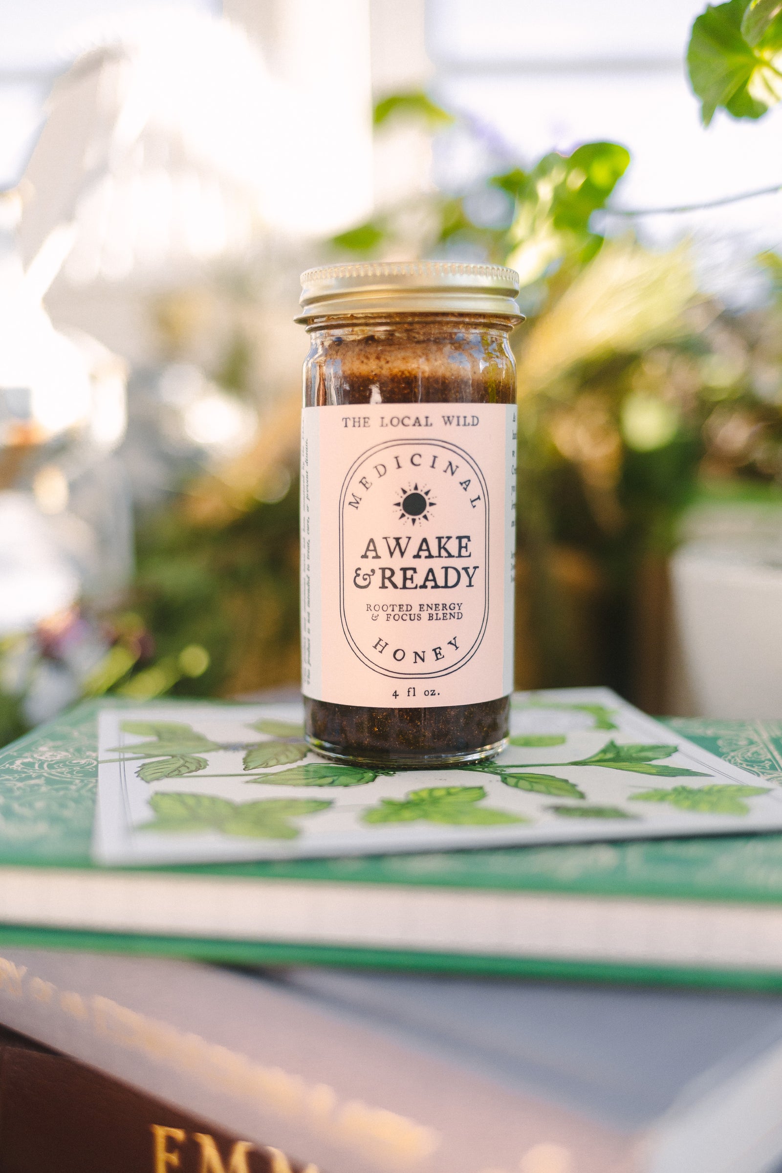 Bottle of awake and ready on a cozy table with greenery and books